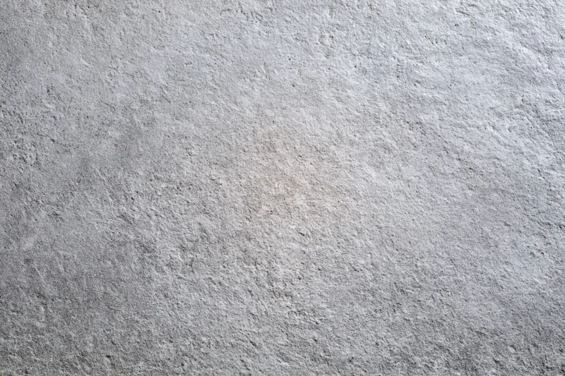 Flat concrete wall surface filling the frame with rough texture and gray tone