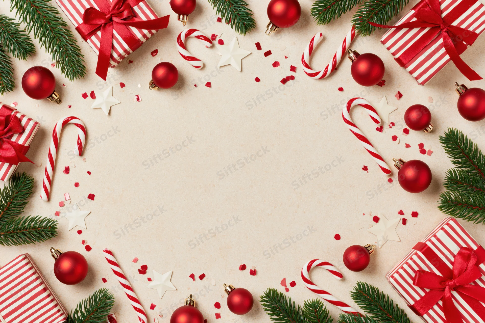 Christmas decorations arranged in a border frame on a light surface with copyspace in the center