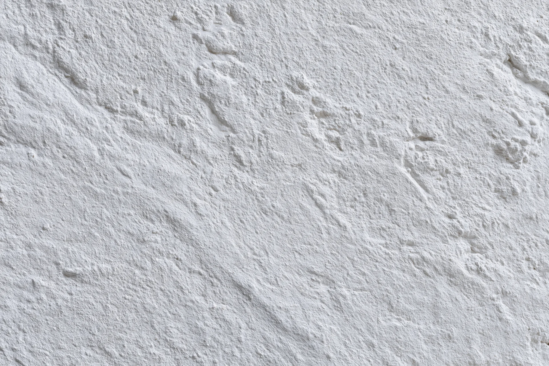 White painted concrete wall surface filling the frame with textured finish