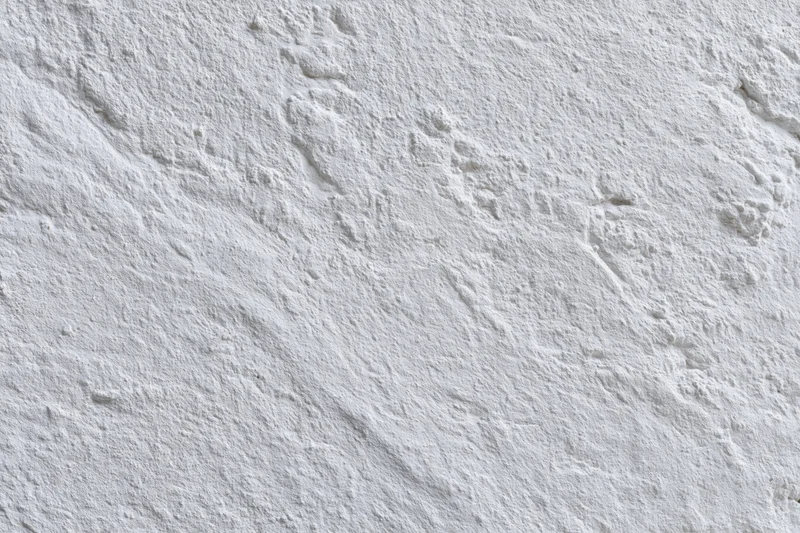 White painted concrete wall surface filling the frame with textured finish