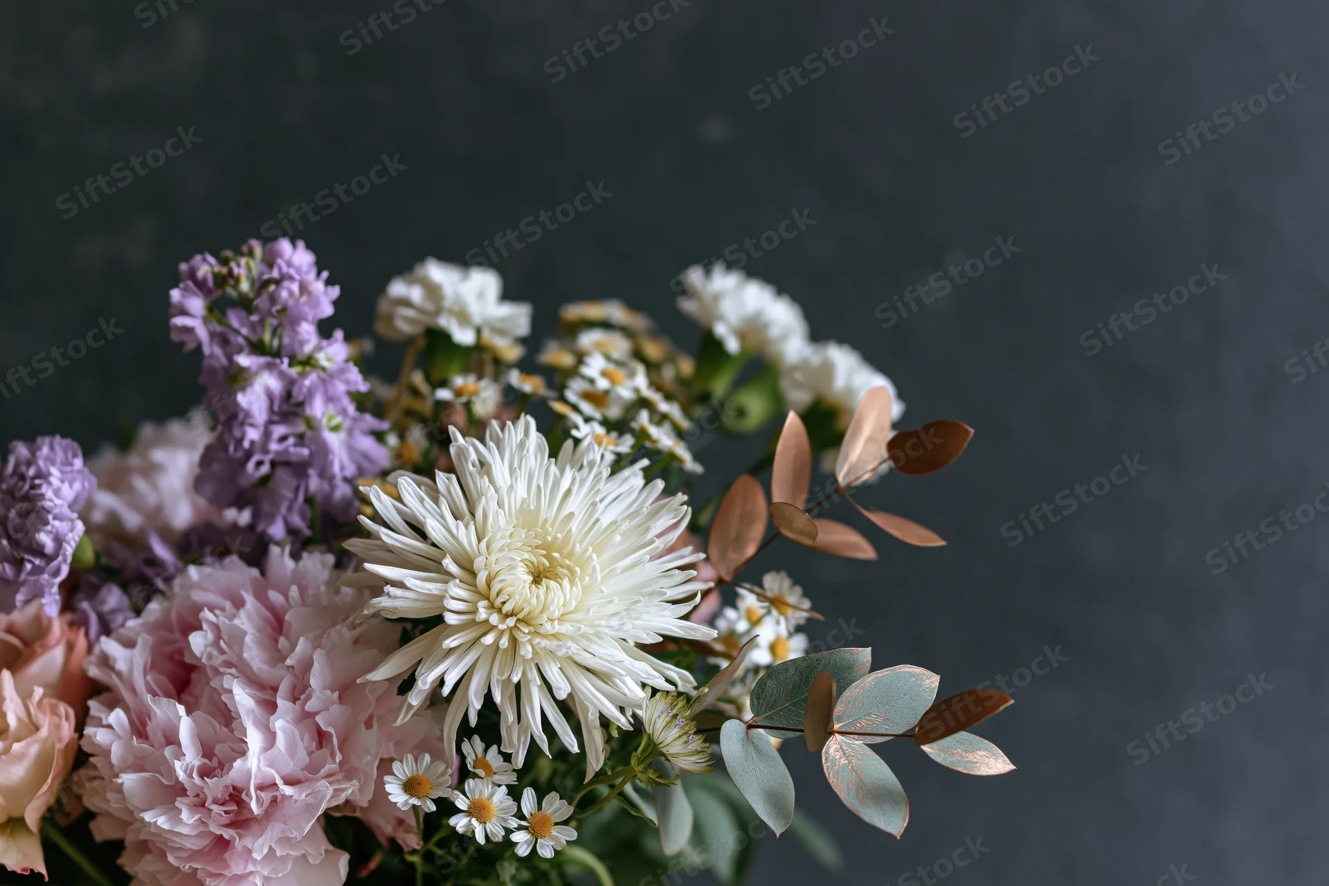 Floral bouquet with white chrysanthemums, pink peonies, purple statice, and eucalyptus foliage against dark grey textured background