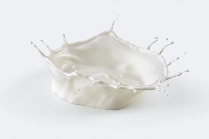 Milk splash frozen in motion forming a crown shape against white background