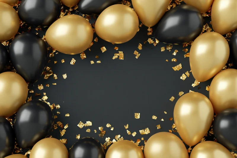 Gold and black metallic balloons arranged in a circular border with scattered gold confetti on a dark background, leaving central copyspace