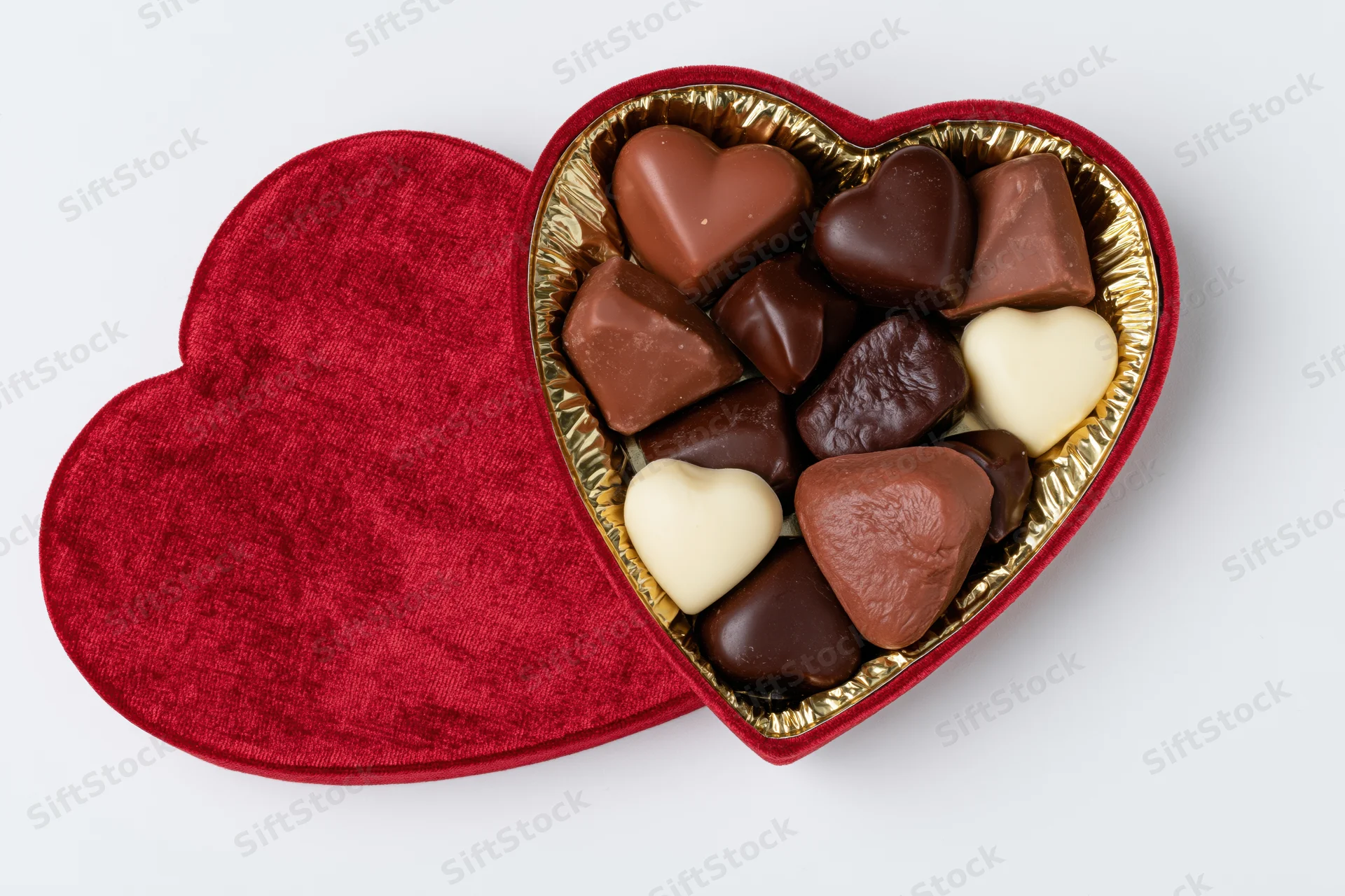 Heart-shaped red velvet chocolate gift box open beside its lid on white background