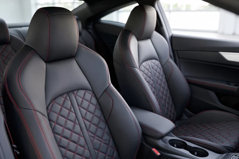 Black leather sport car seats with red stitching and diamond pattern in vehicle interior