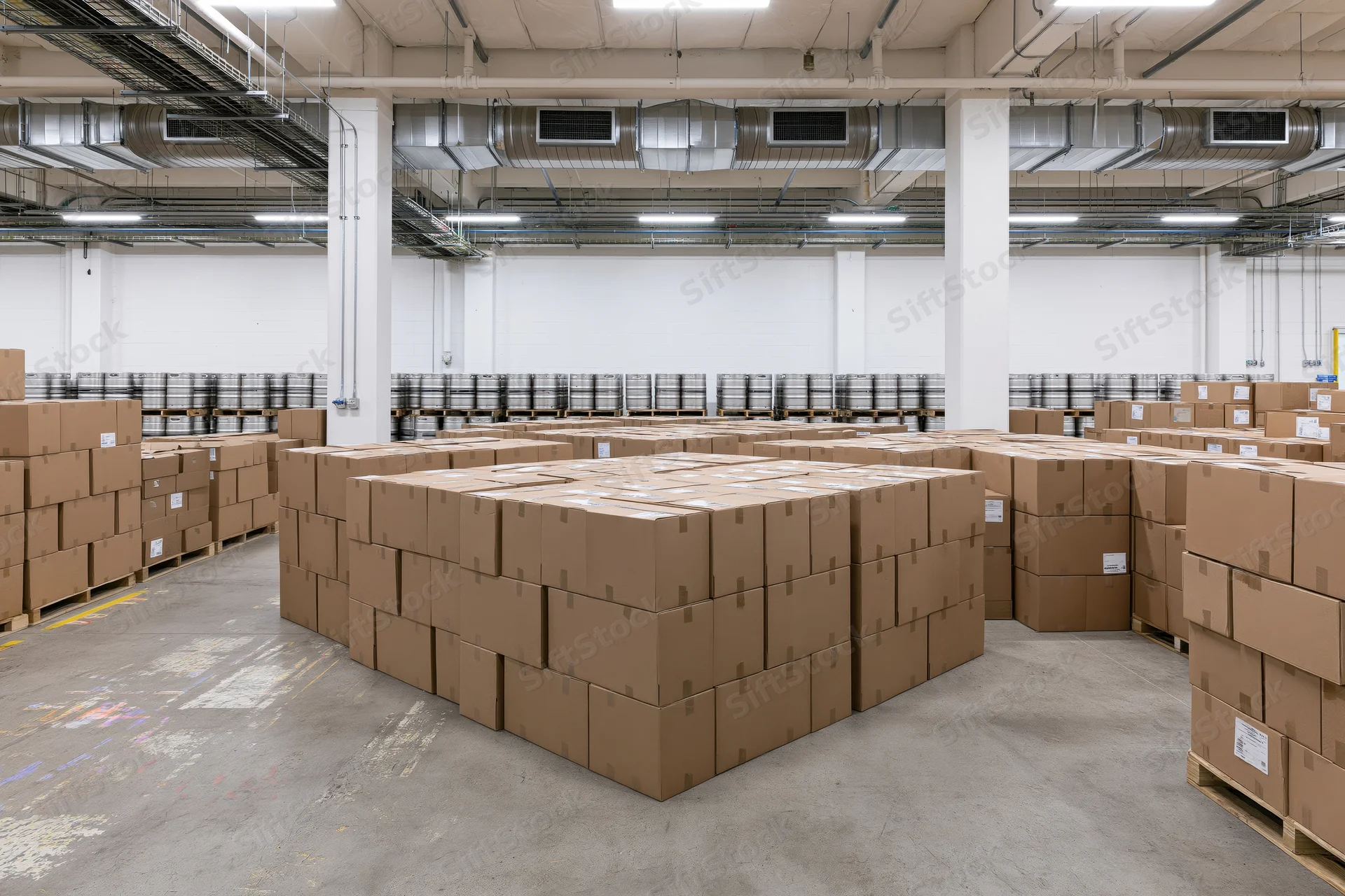 Tall stacks of brown cardboard boxes arranged on pallets in a commercial warehouse interior