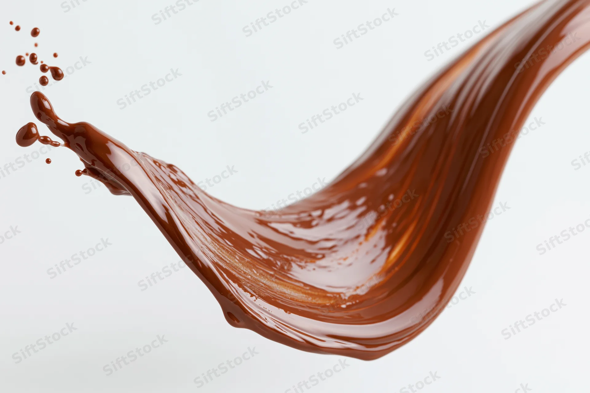 Liquid chocolate pouring in a sweeping wave shape against white background