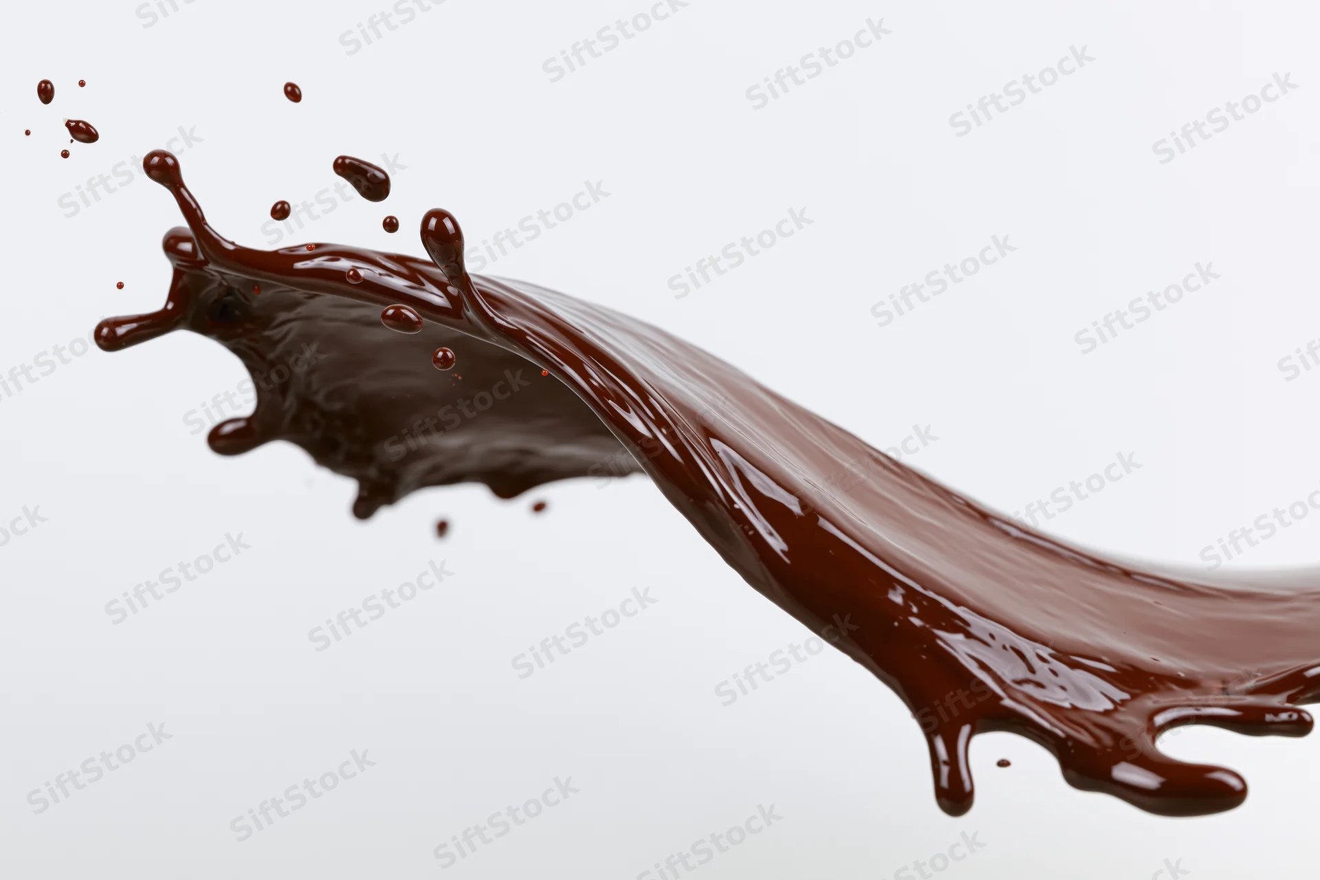 Dark chocolate liquid mid-splash frozen in motion against white background