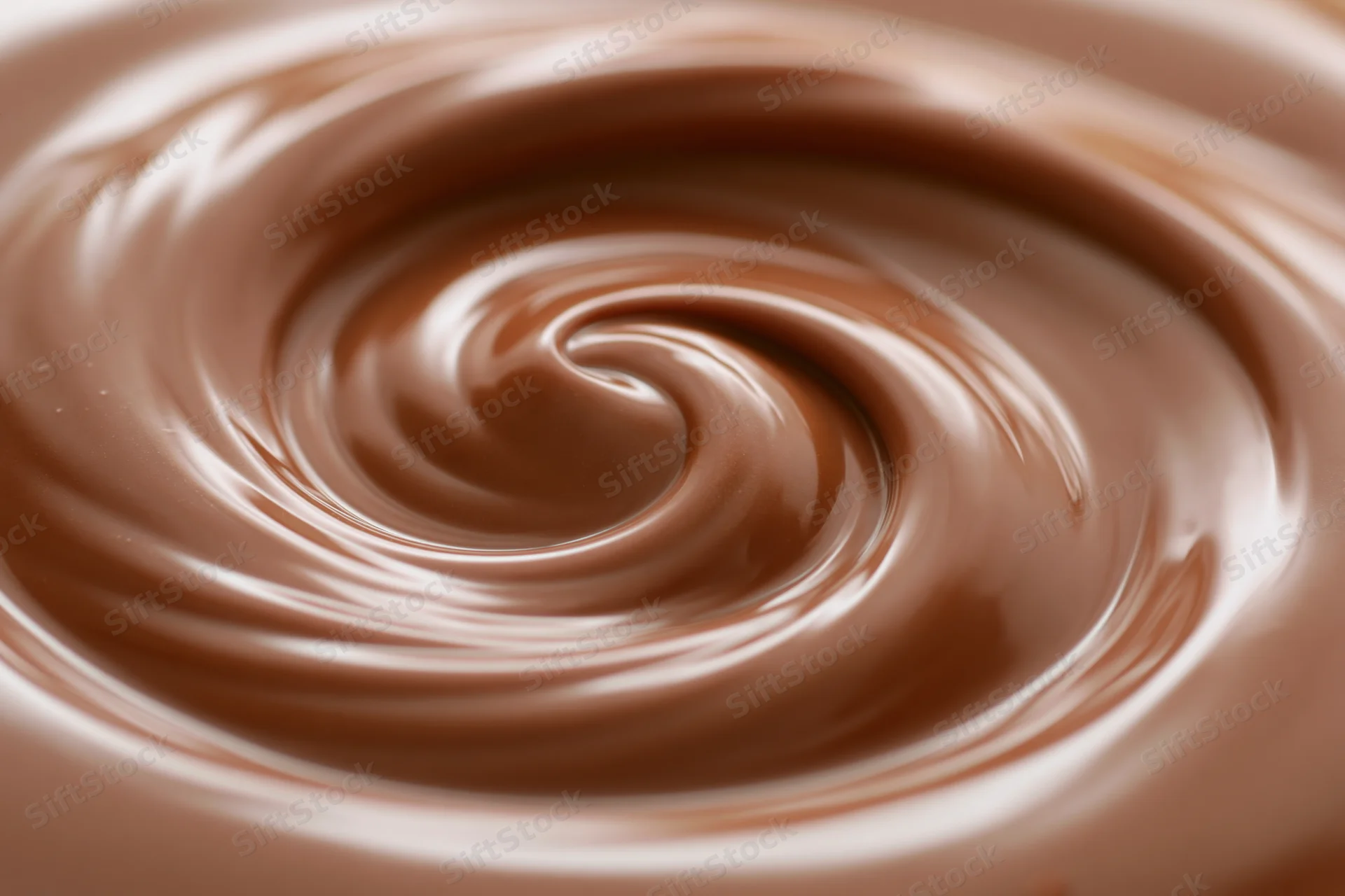 Molten milk chocolate swirling in a tight spiral in extreme closeup