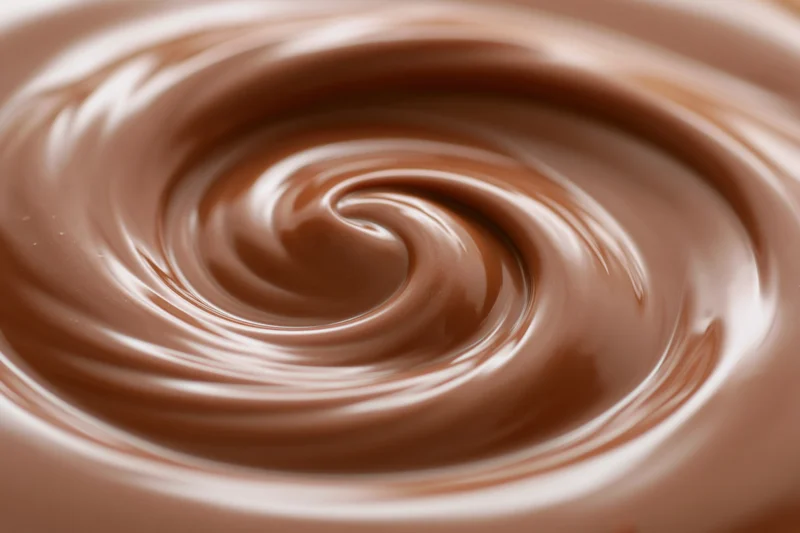 Molten milk chocolate swirling in a tight spiral in extreme closeup