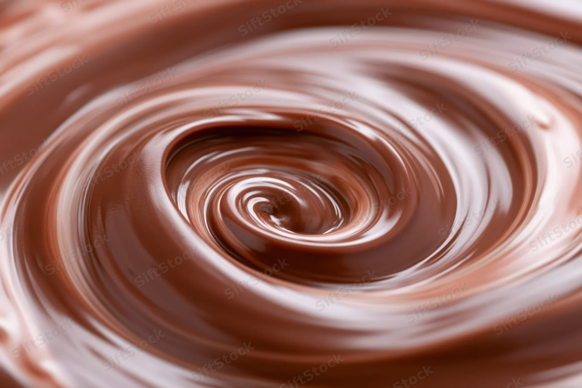 Molten milk chocolate swirling in a tight spiral closeup