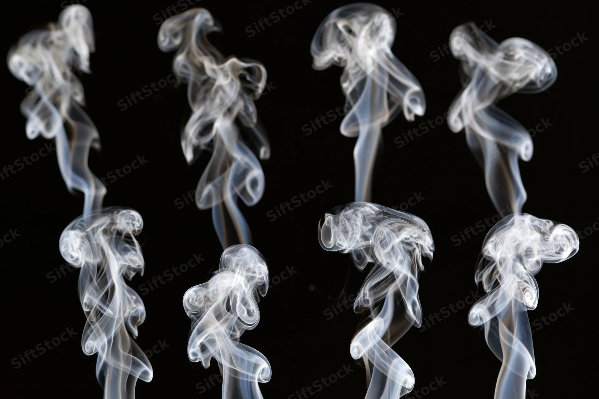 White smoke wisps arranged in a grid pattern against a black background