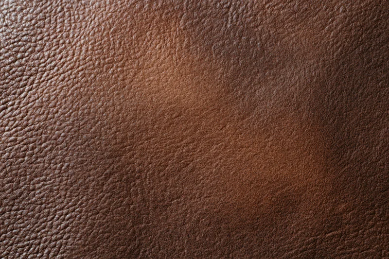 Close-up of a plain matte brown leather surface filling the frame