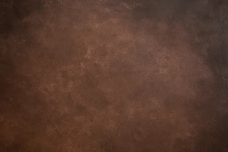 Plain mottled brown studio backdrop texture with no subject