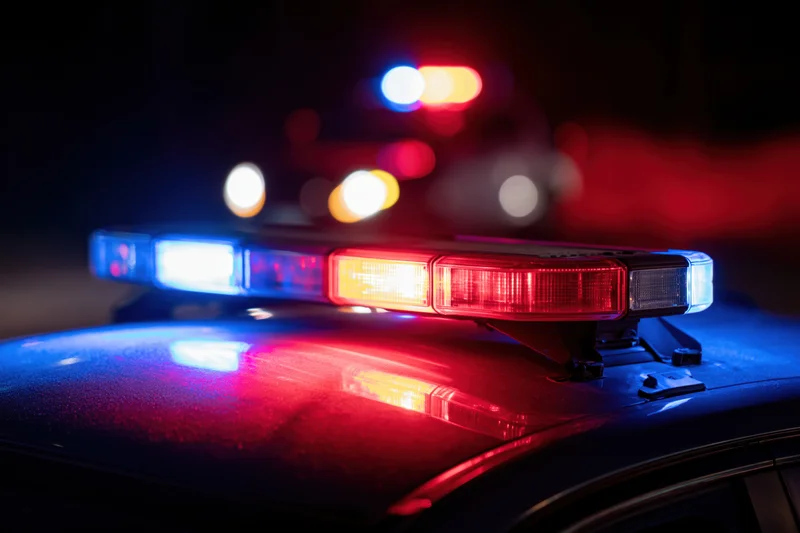 Police car light bar flashing red and blue at night close-up on rooftop