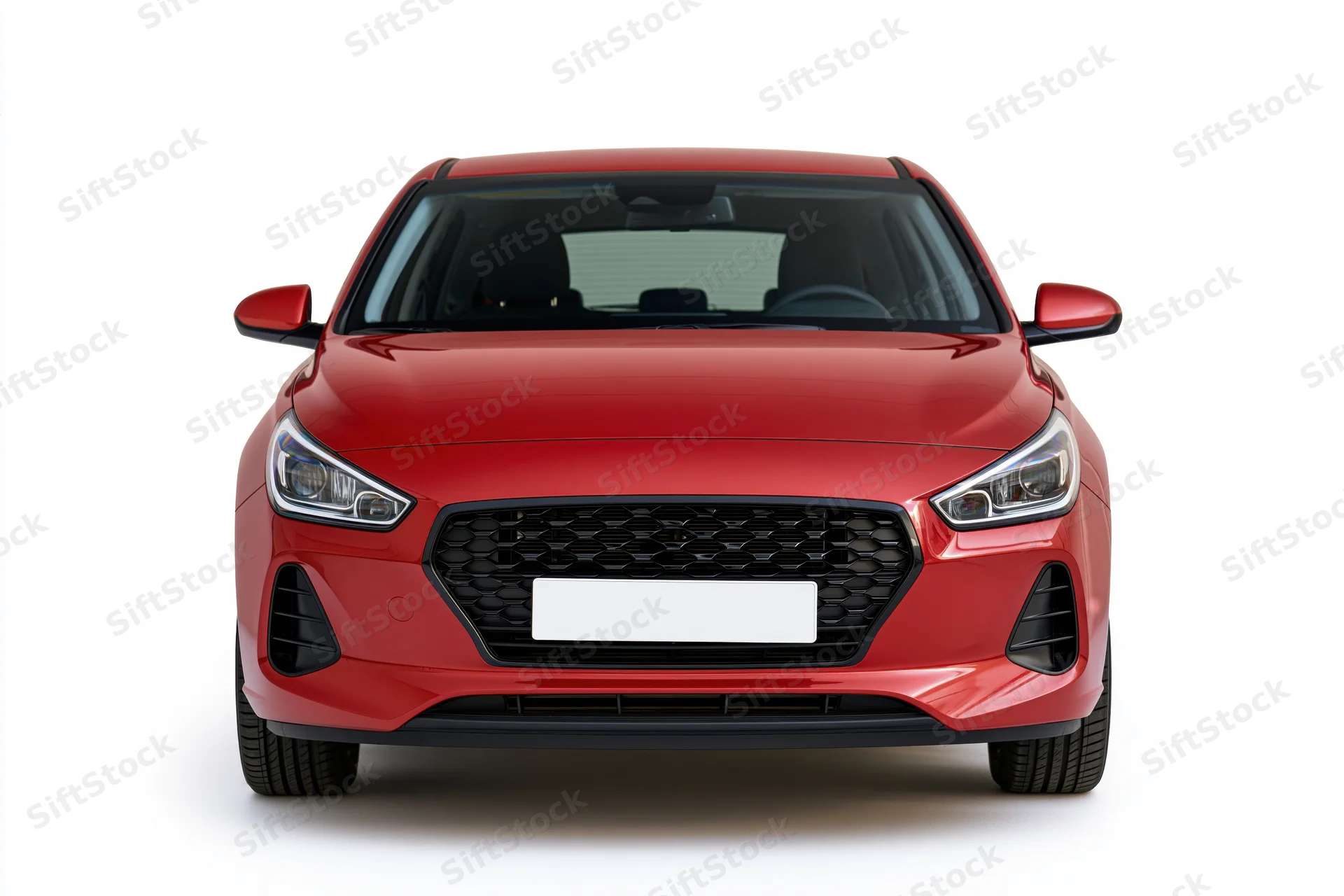 Red compact hatchback photographed straight-on from front against white background