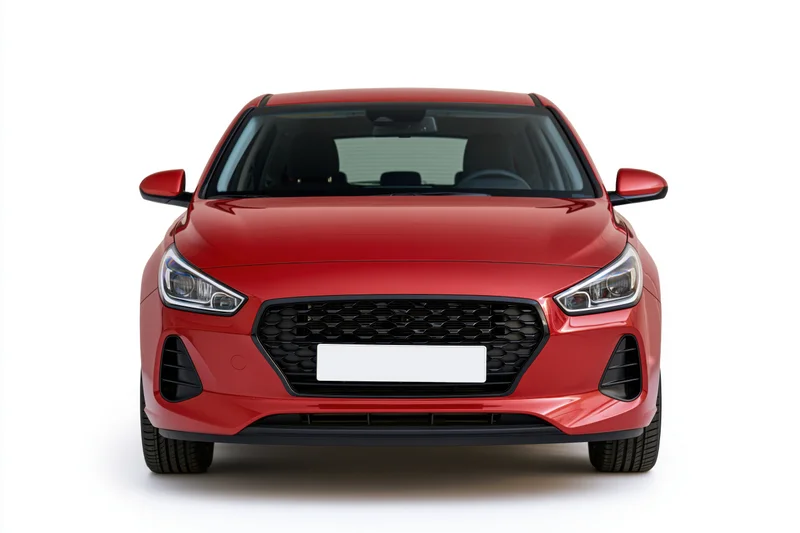 Red compact hatchback photographed straight-on from front against white background