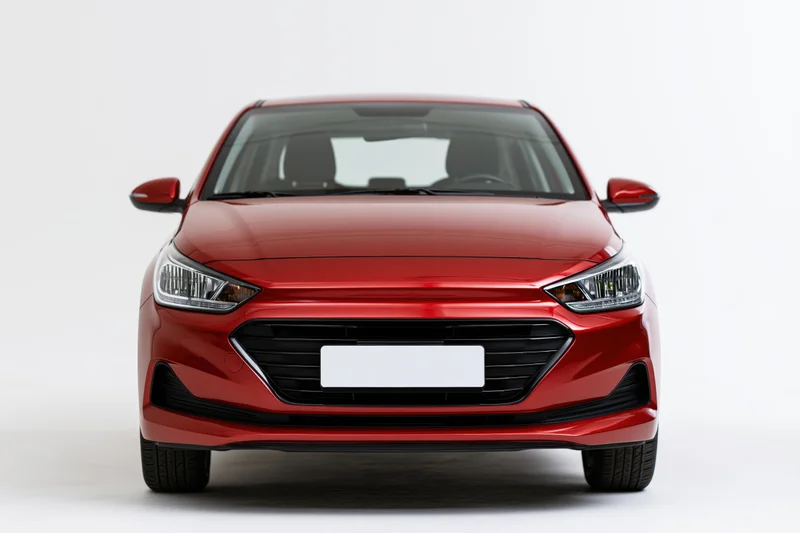 Red compact hatchback photographed straight-on from front in studio setting