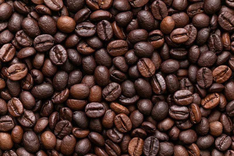 Roasted coffee beans arranged in a flat lay filling the frame
