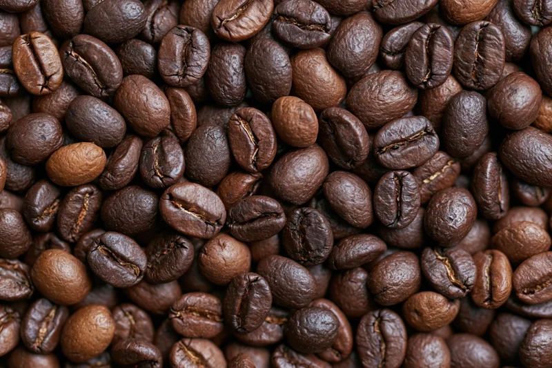 Roasted coffee beans arranged in a flat lay filling the frame