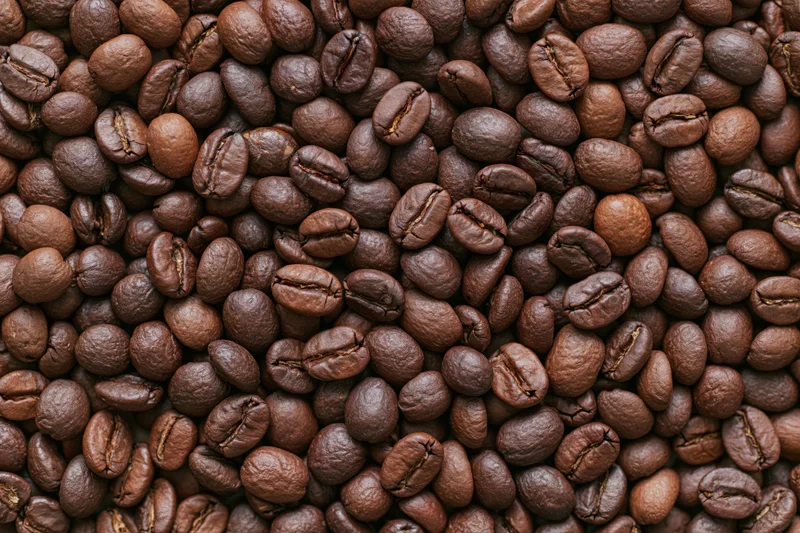Roasted coffee beans arranged in a flat lay filling the frame
