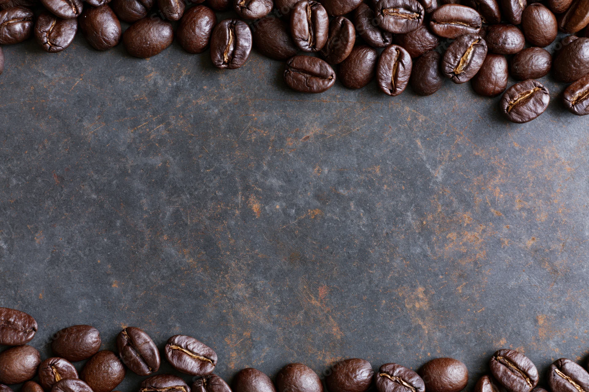 Roasted coffee beans arranged along top and bottom edges on dark textured surface