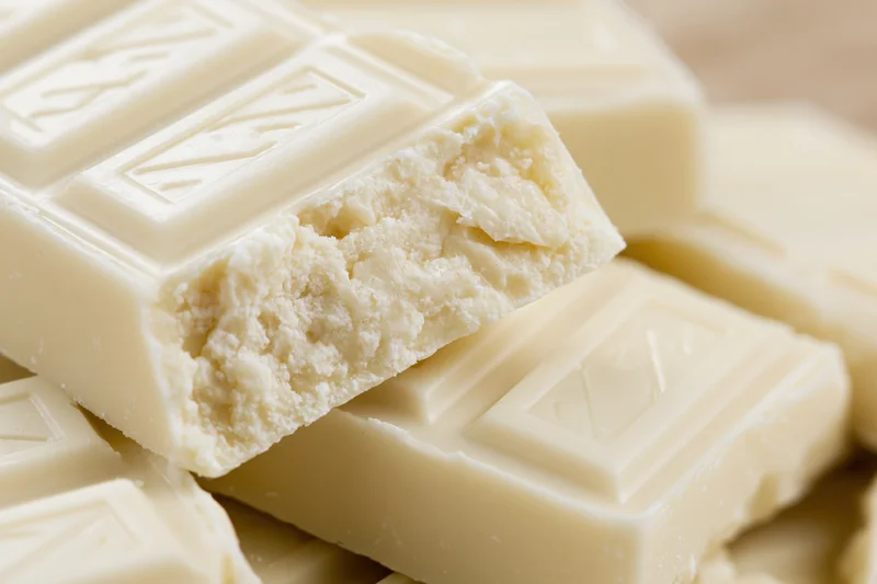 Broken white chocolate squares piled together in a close-up view