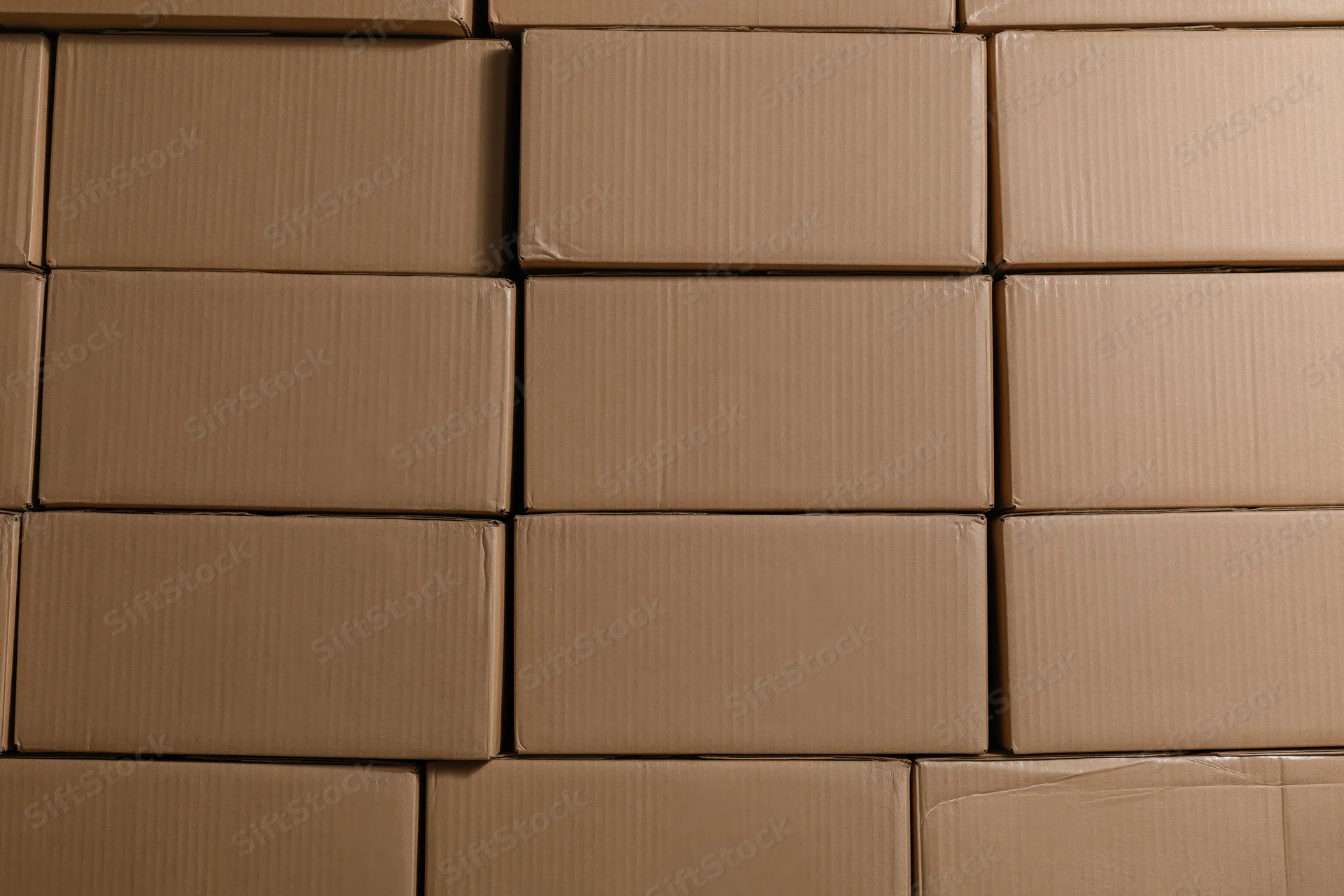Stacked rows of identical sealed cardboard shipping boxes arranged in a warehouse storage area