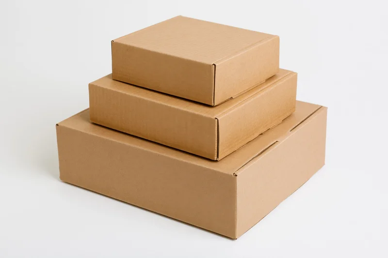 Three plain brown cardboard shipping boxes stacked in descending size on a white background