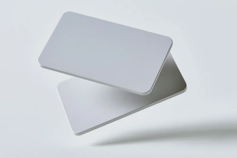 Two blank white business cards with rounded corners floating in midair against a plain white background