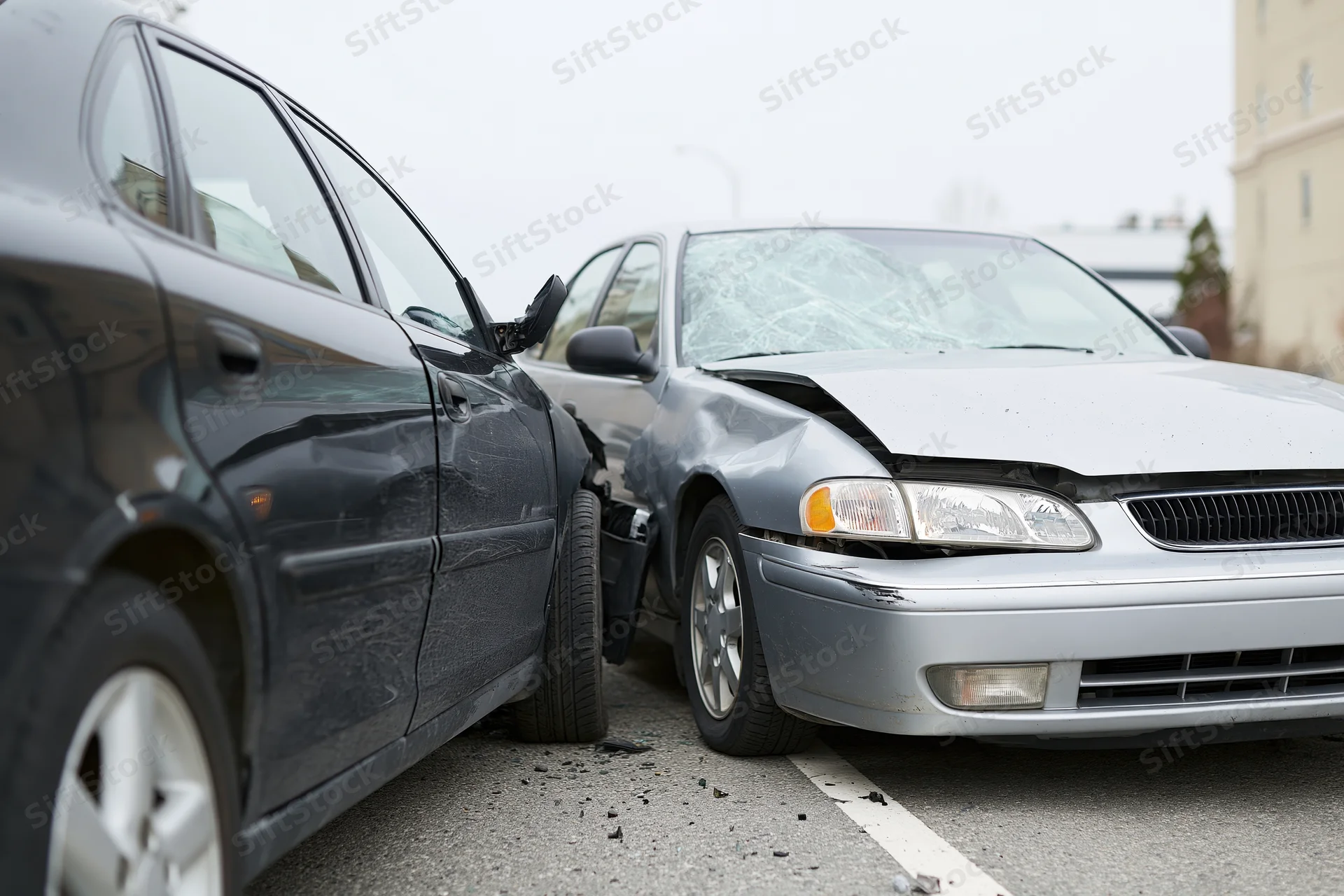 Two sedans involved in a front-end collision on an urban street