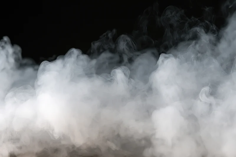 White smoke and mist drifting along the bottom and sides against a black background
