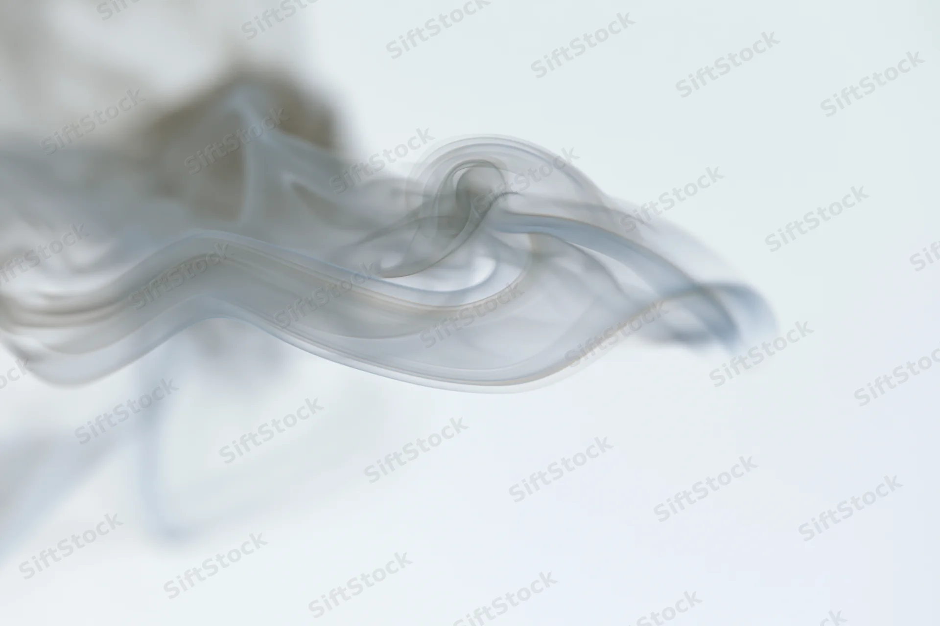Wispy smoke curling and dispersing mid-air against a pure white background