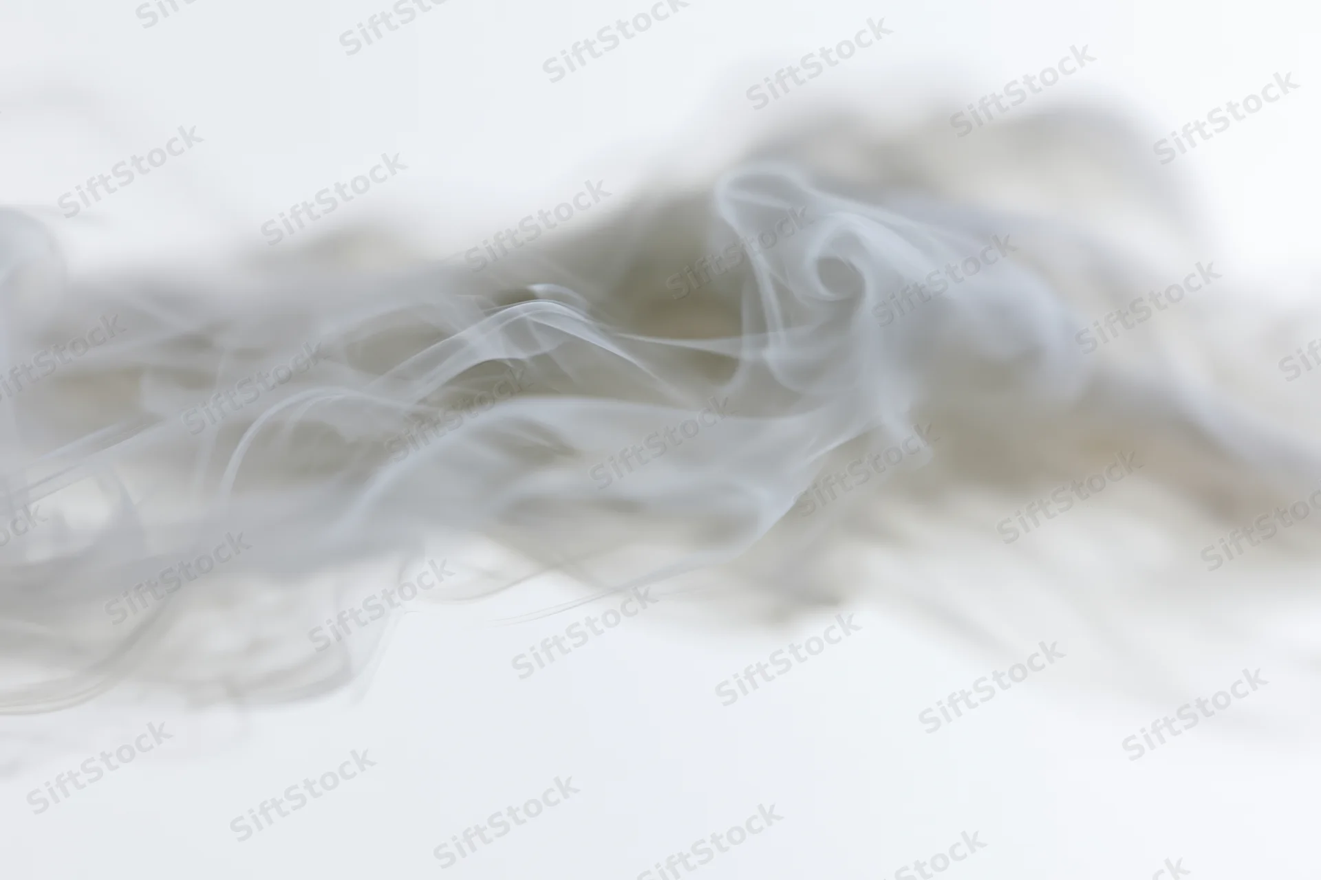 Wispy smoke drifting and dispersing against a plain white background