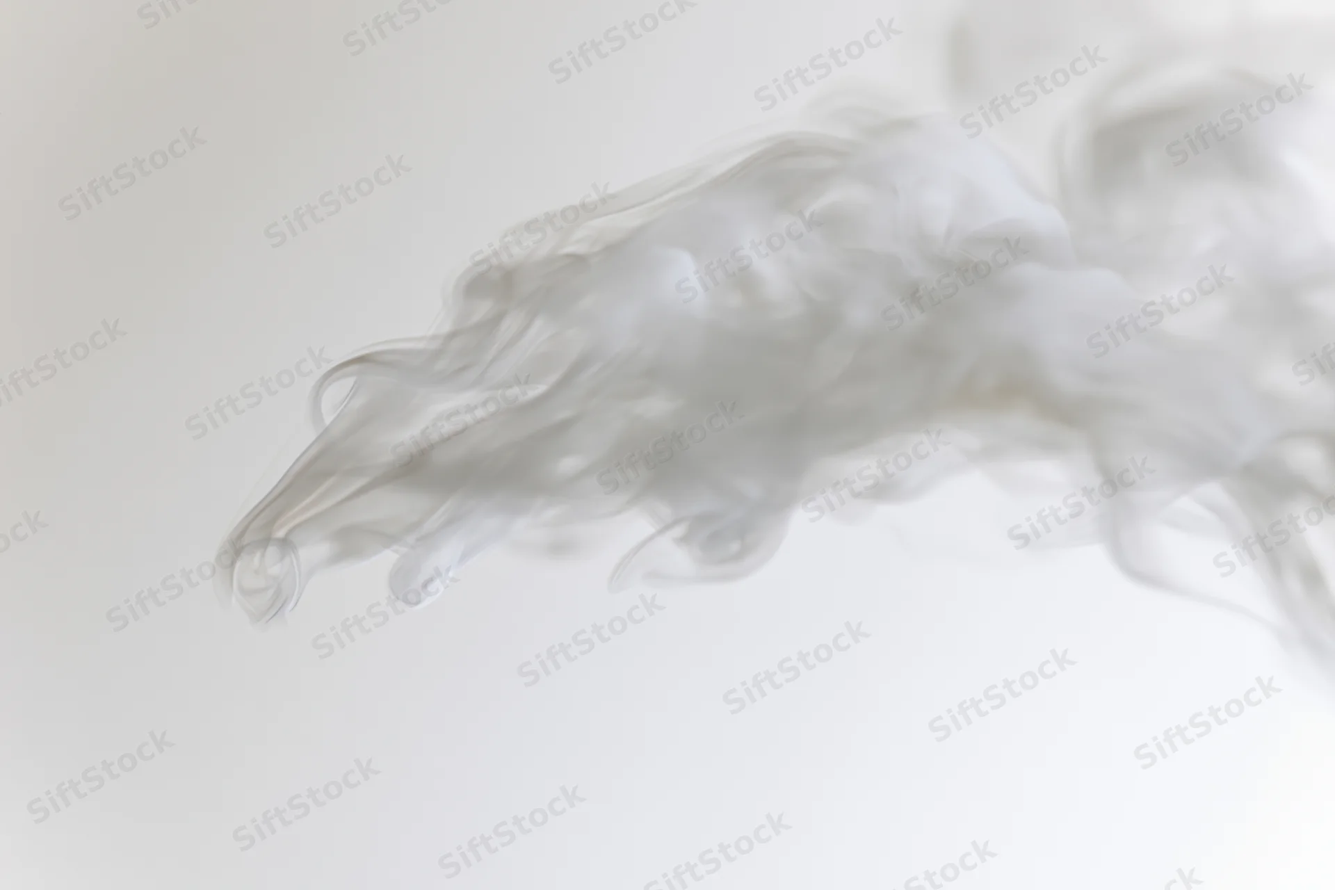 Wispy white smoke drifting and dispersing against a plain background
