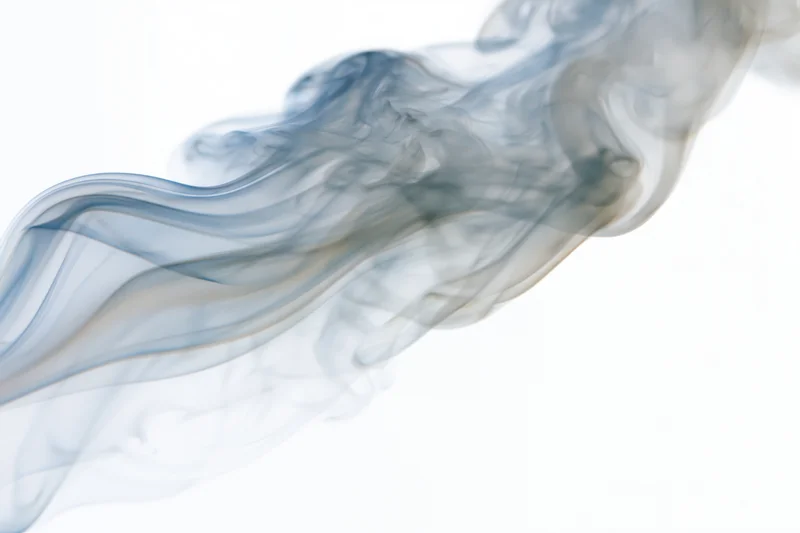 Wispy white smoke drifting and dispersing against a pure white background