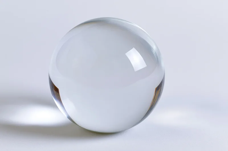 Clear glass sphere resting on plain white surface centered in frame