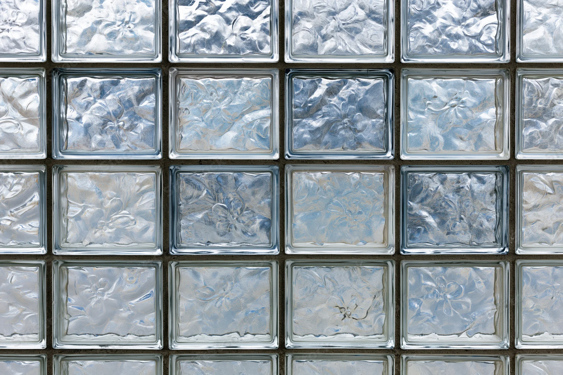 Flat wall of square textured glass blocks arranged in a grid pattern