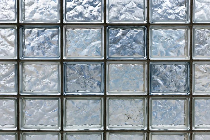 Flat wall of square textured glass blocks arranged in a grid pattern
