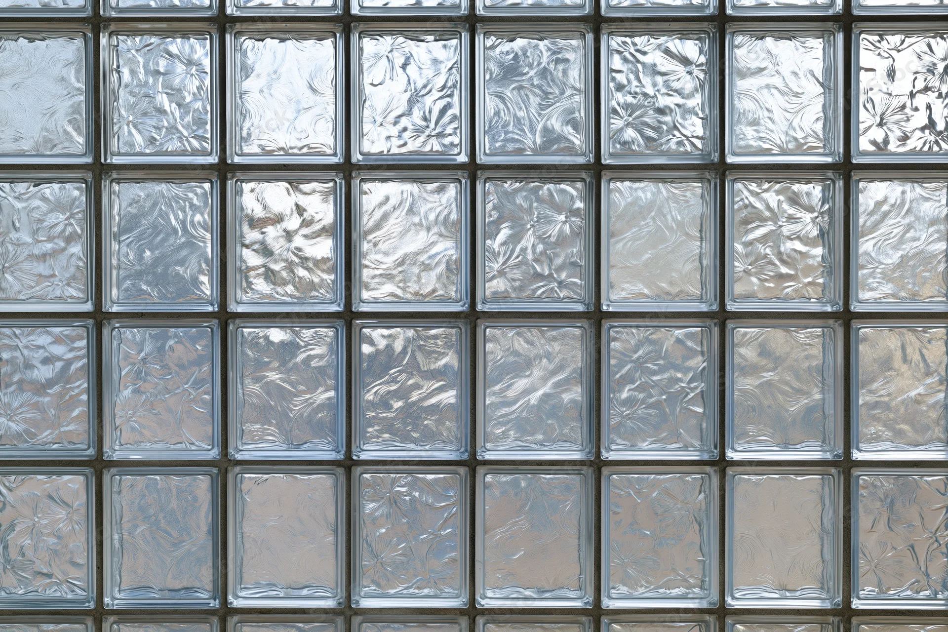 Flat wall made of square textured glass blocks arranged in a grid pattern