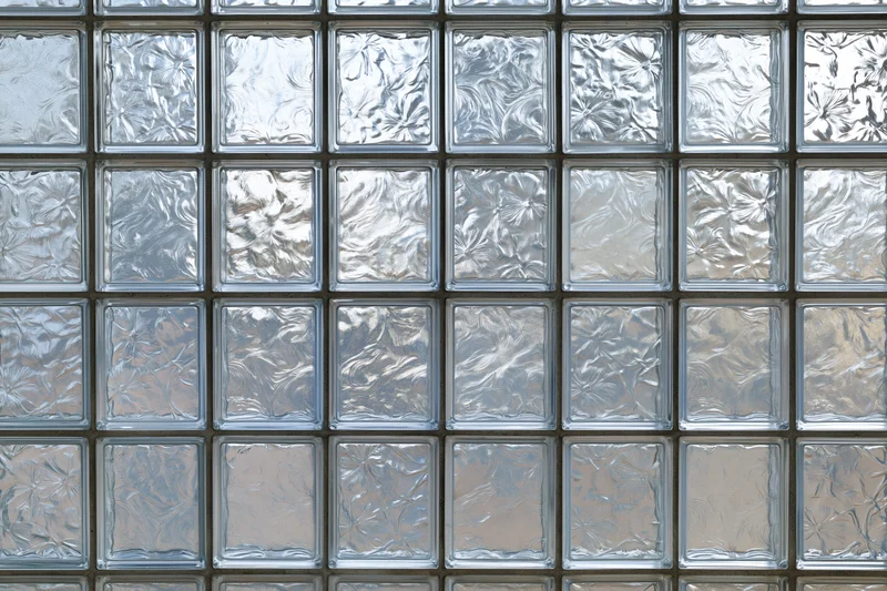 Flat wall made of square textured glass blocks arranged in a grid pattern