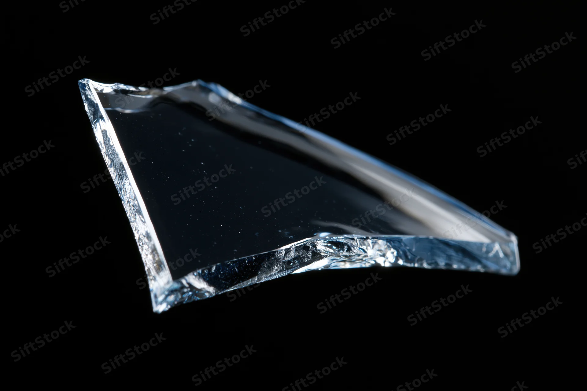 Jagged shard of broken glass floating against a pure black background