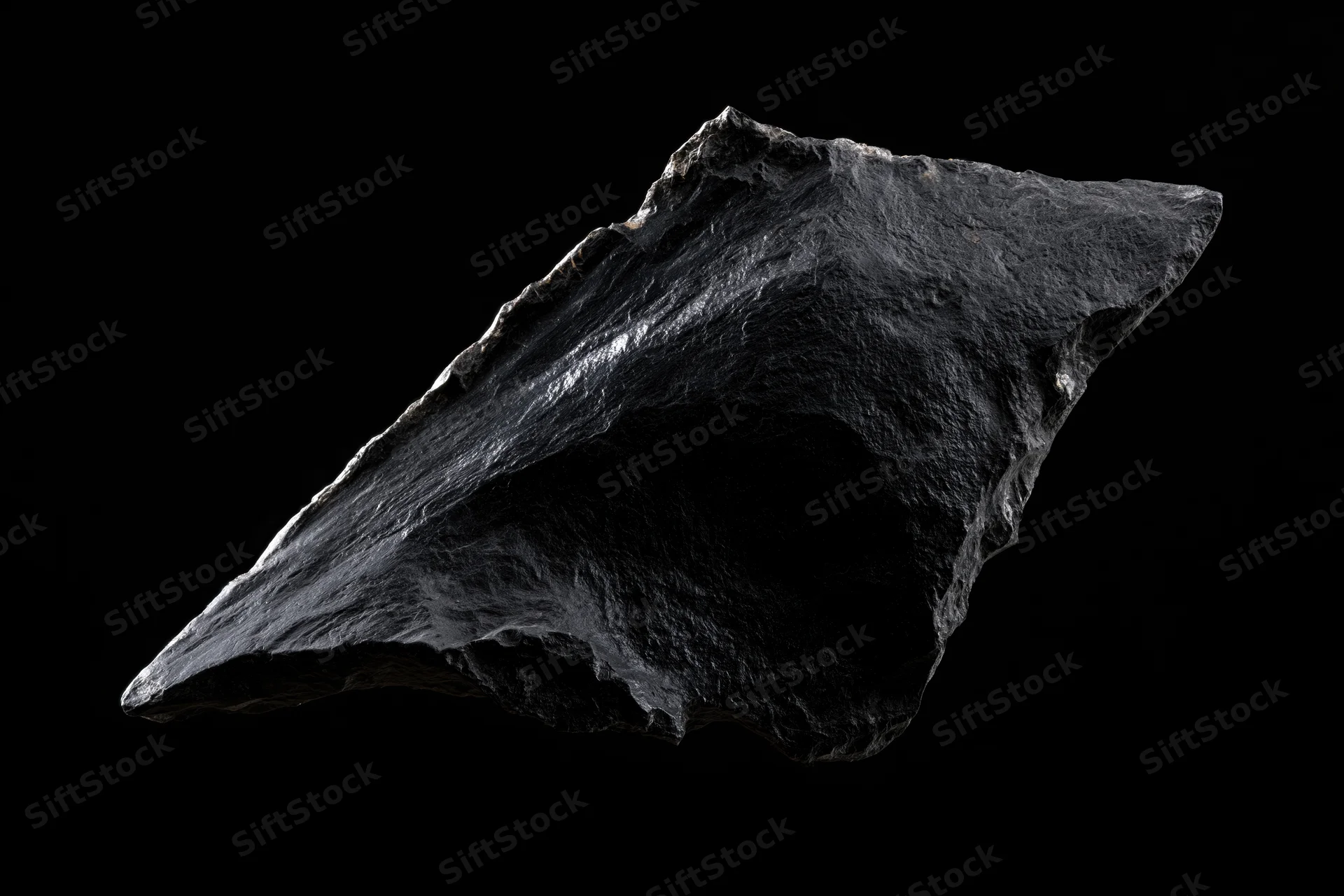 Rough obsidian stone fragment floating against black background