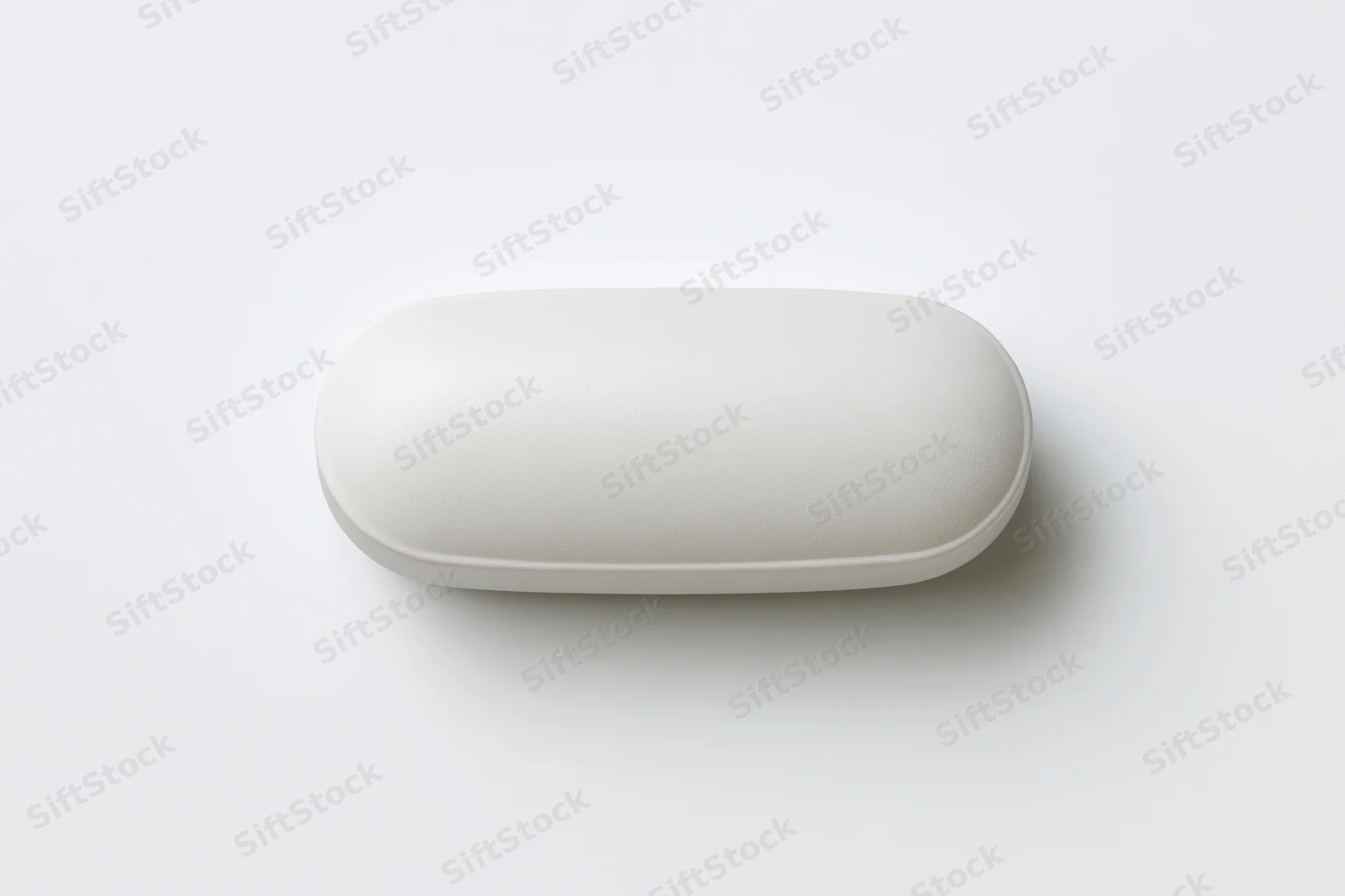 White oval pill capsule lying flat centered on plain white surface