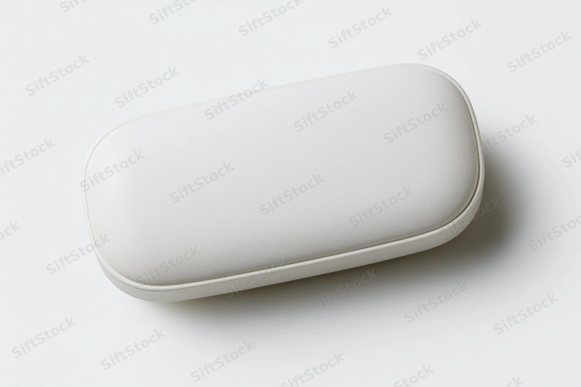 White oval pill capsule lying flat centered on plain white surface