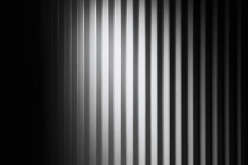 Close-up of a corrugated metal surface with vertical ribs and gray tonal gradient