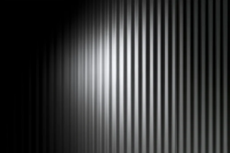 Close-up of a corrugated metal surface with vertical ribs and light gradient