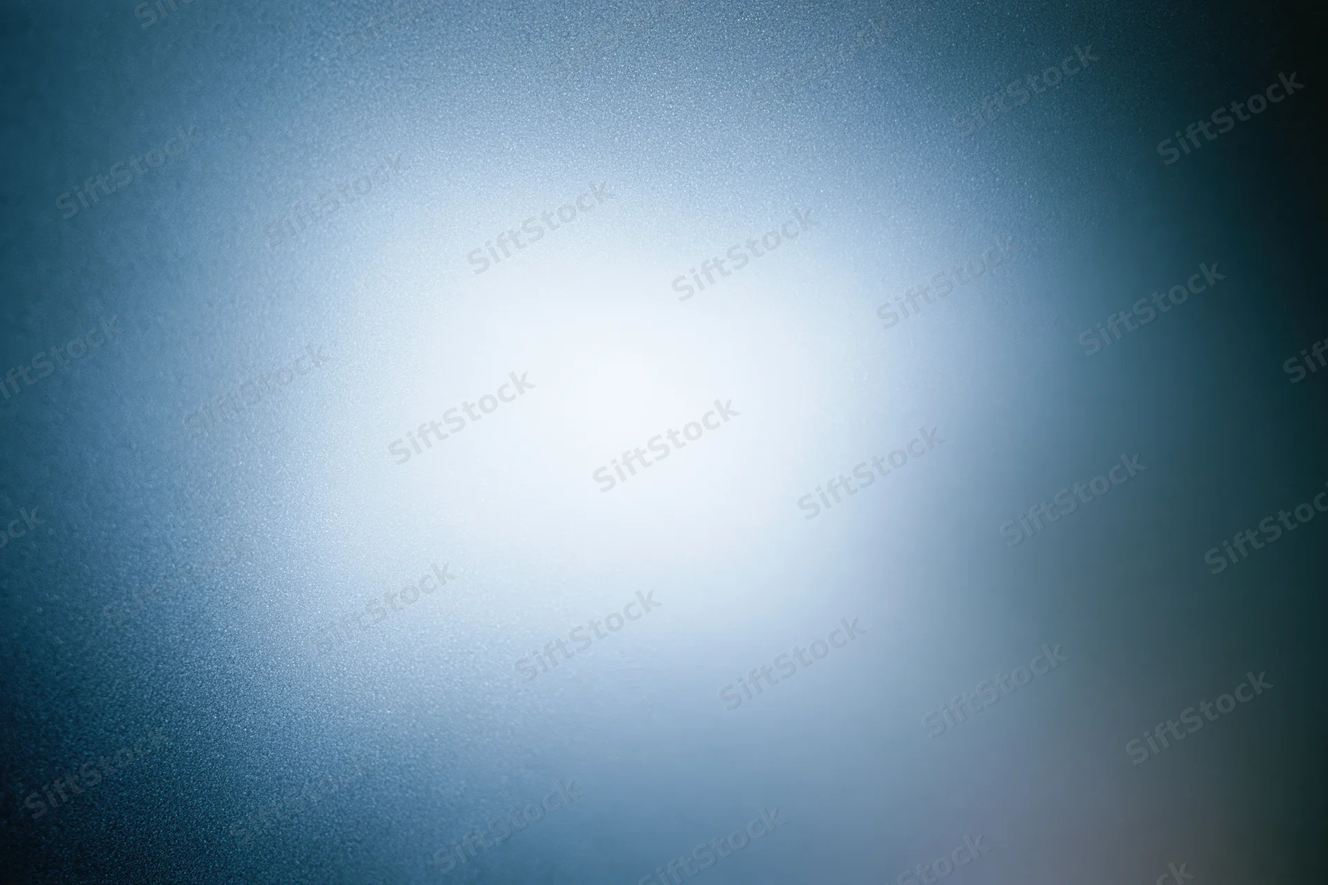 Frosted glass surface with diffused light creating a soft blue gradient background