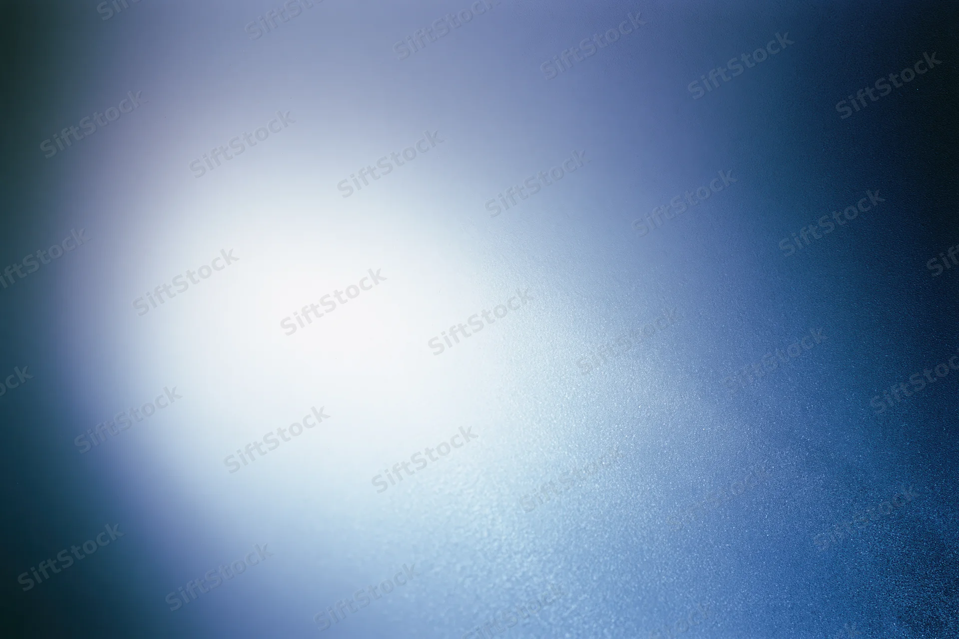 Frosted glass surface with diffused light creating a soft blue gradient background