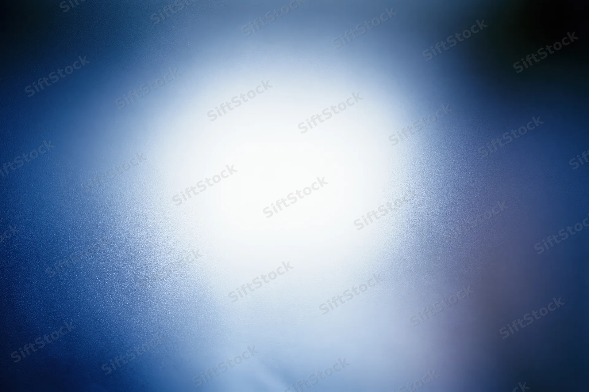 Frosted glass surface with diffused light creating soft blue and white glow
